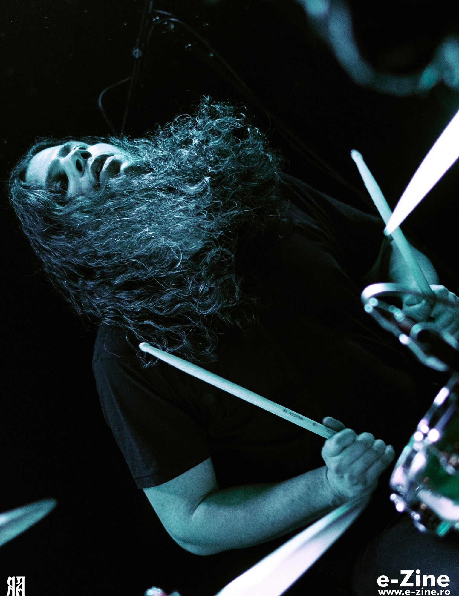 Batteur en pleine frappe, baguette levée, photographie de concert en noir et blanc