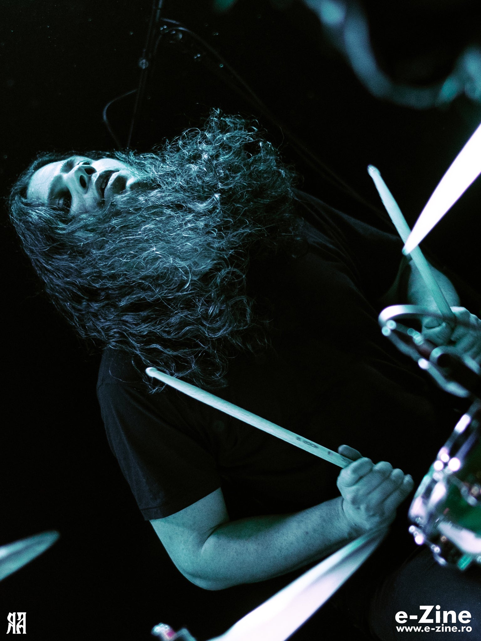 Batteur en pleine frappe, baguette levée, photographie de concert en noir et blanc